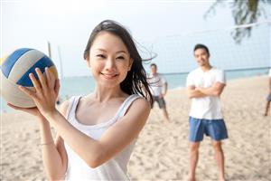 Young adults playing beach volleyball
